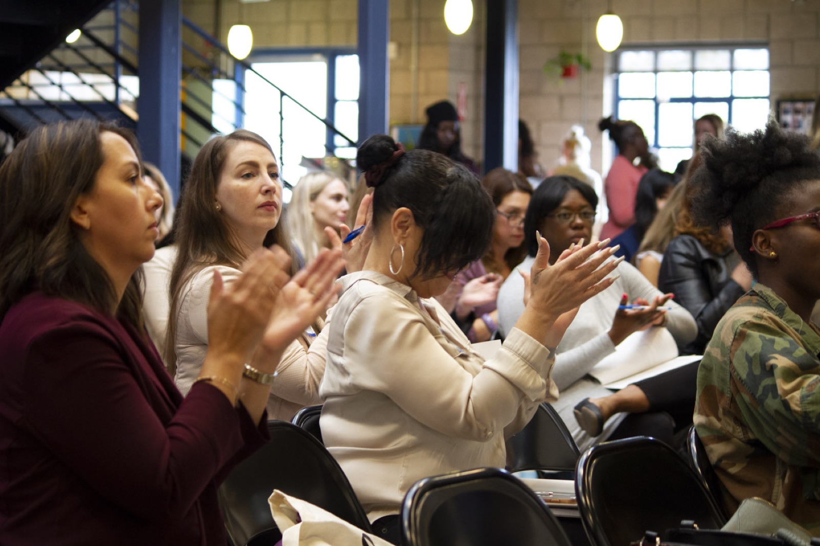 Women applauding at Simone's 2018 summit