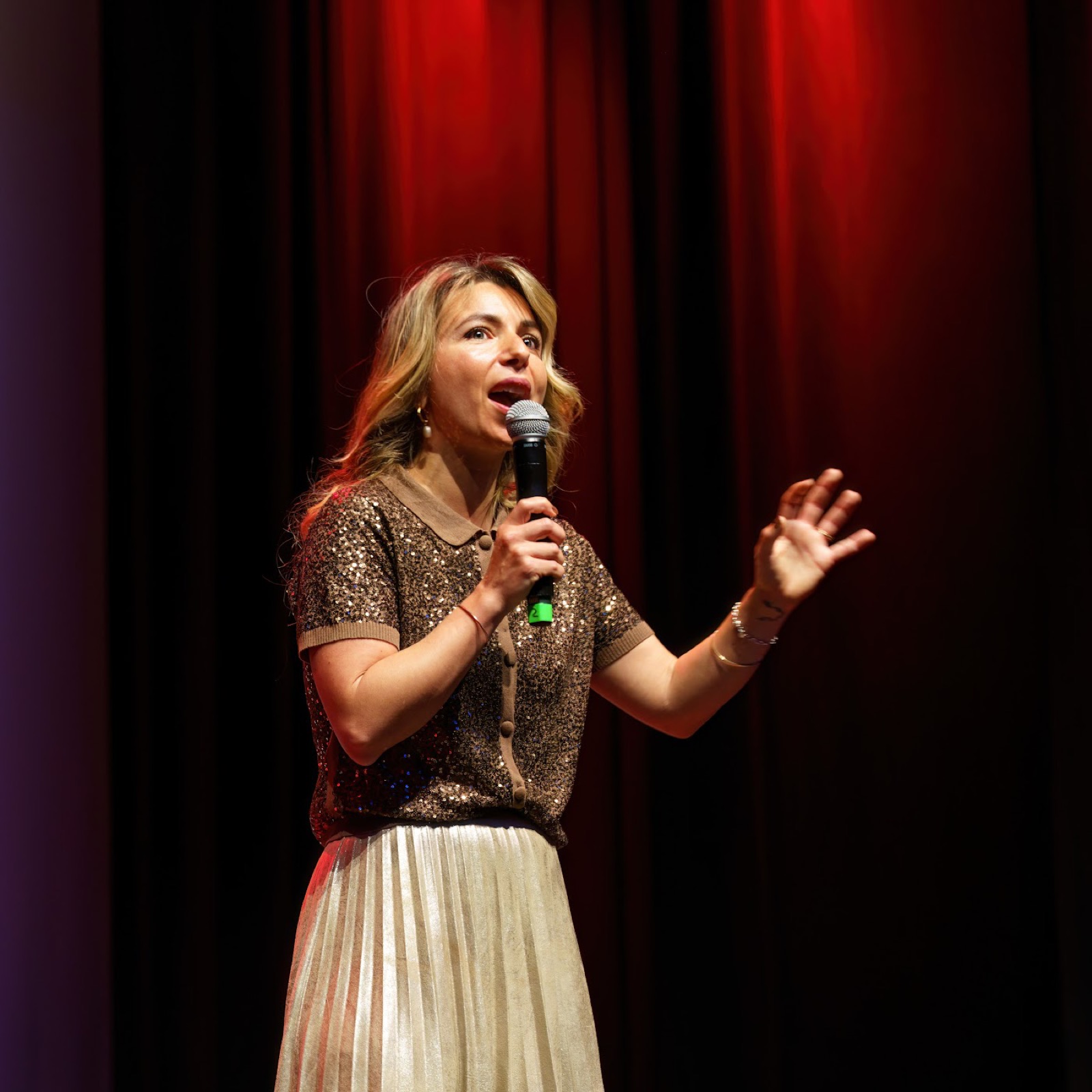 Simone speaking on stage with a microphone